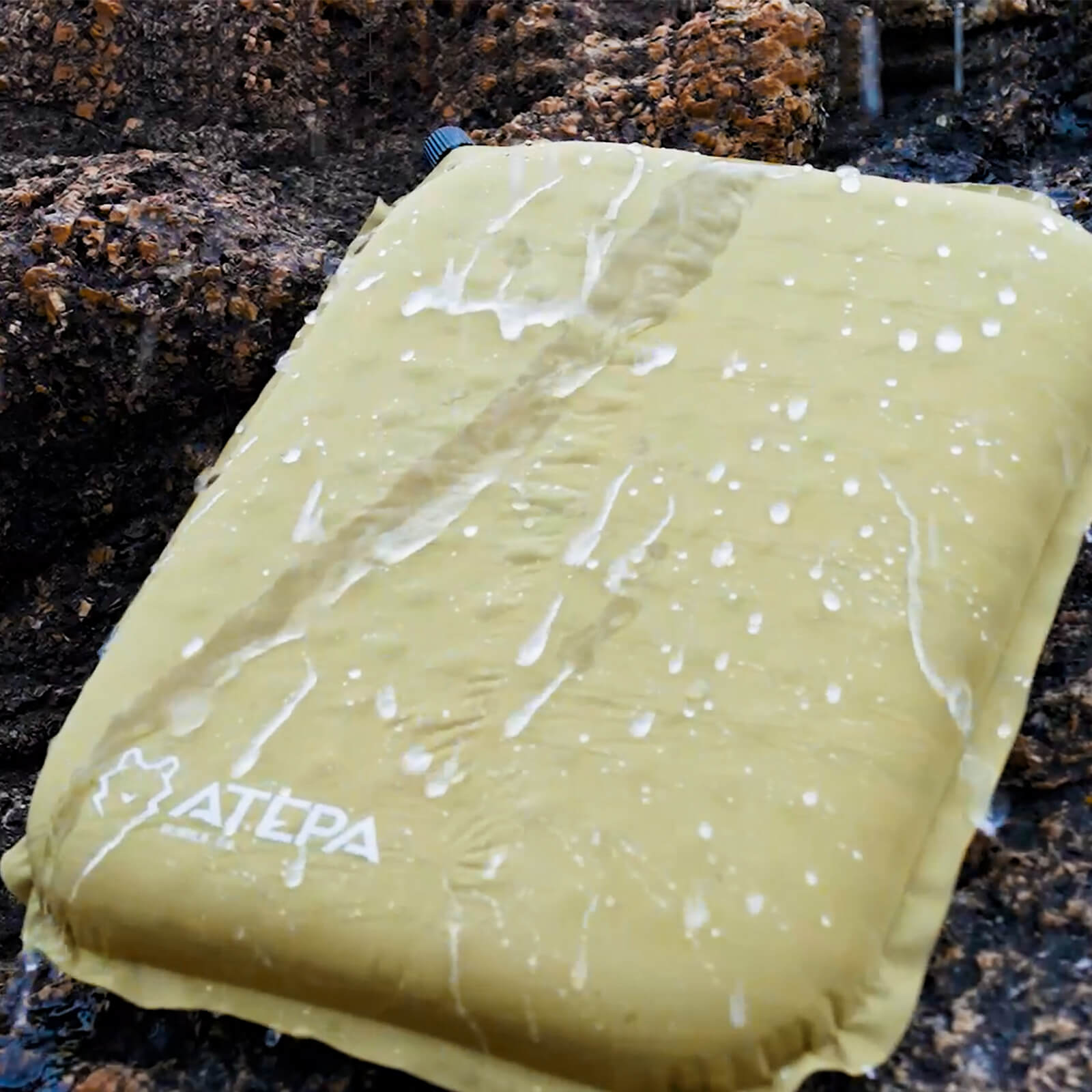 Grey seat cushion for outdoor use placed on grass and camping ground